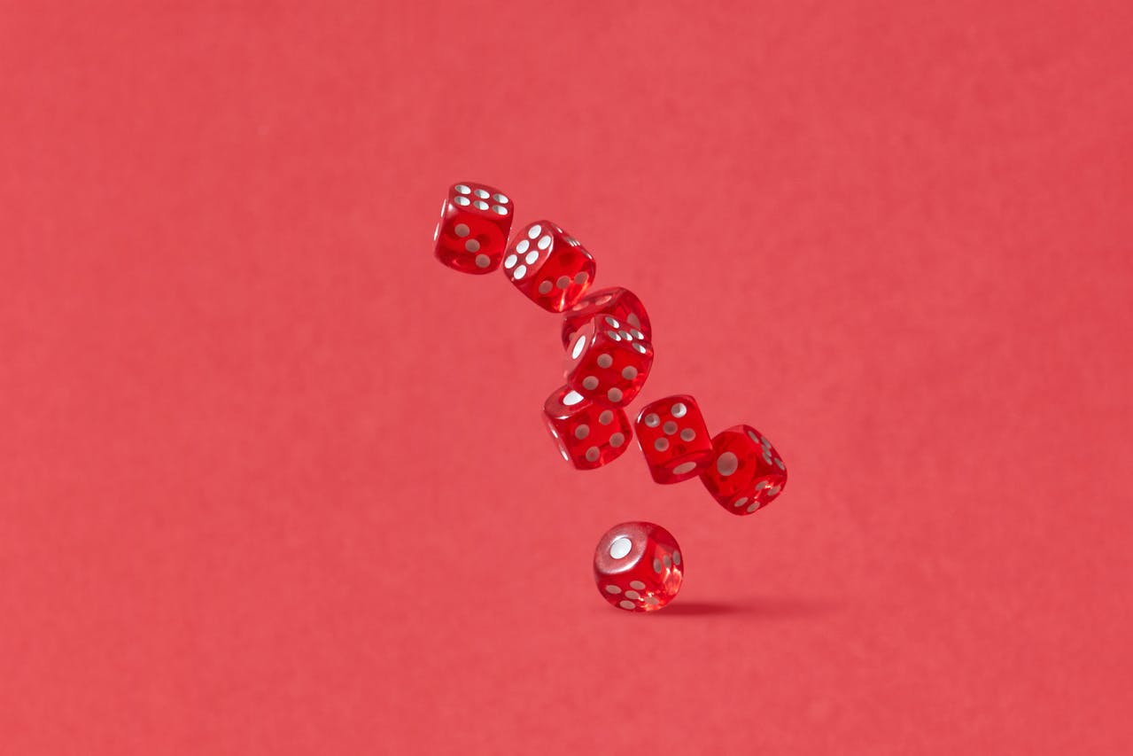 Red multi-sided dice against a red background, from Pexels: Photo by DS stories: https://www.pexels.com/photo/red-dice-in-the-air-6990398/